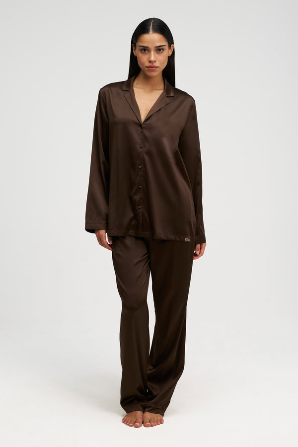 Woman wearing silk PJ in brown, front shot.