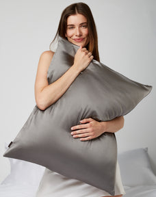 Woman hugging a Silk gray pillow