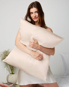 Woman hugging a Silk Beige pillow
