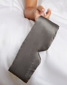 Hand of a woman holding a Silk Gray Sleeping Eyemask