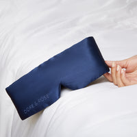 Hand of a woman holding a Silk Blue Sleeping Eyemask