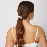 Woman wearing a Silk Large Scrunchie in Champagne Beige from Dore and Rose