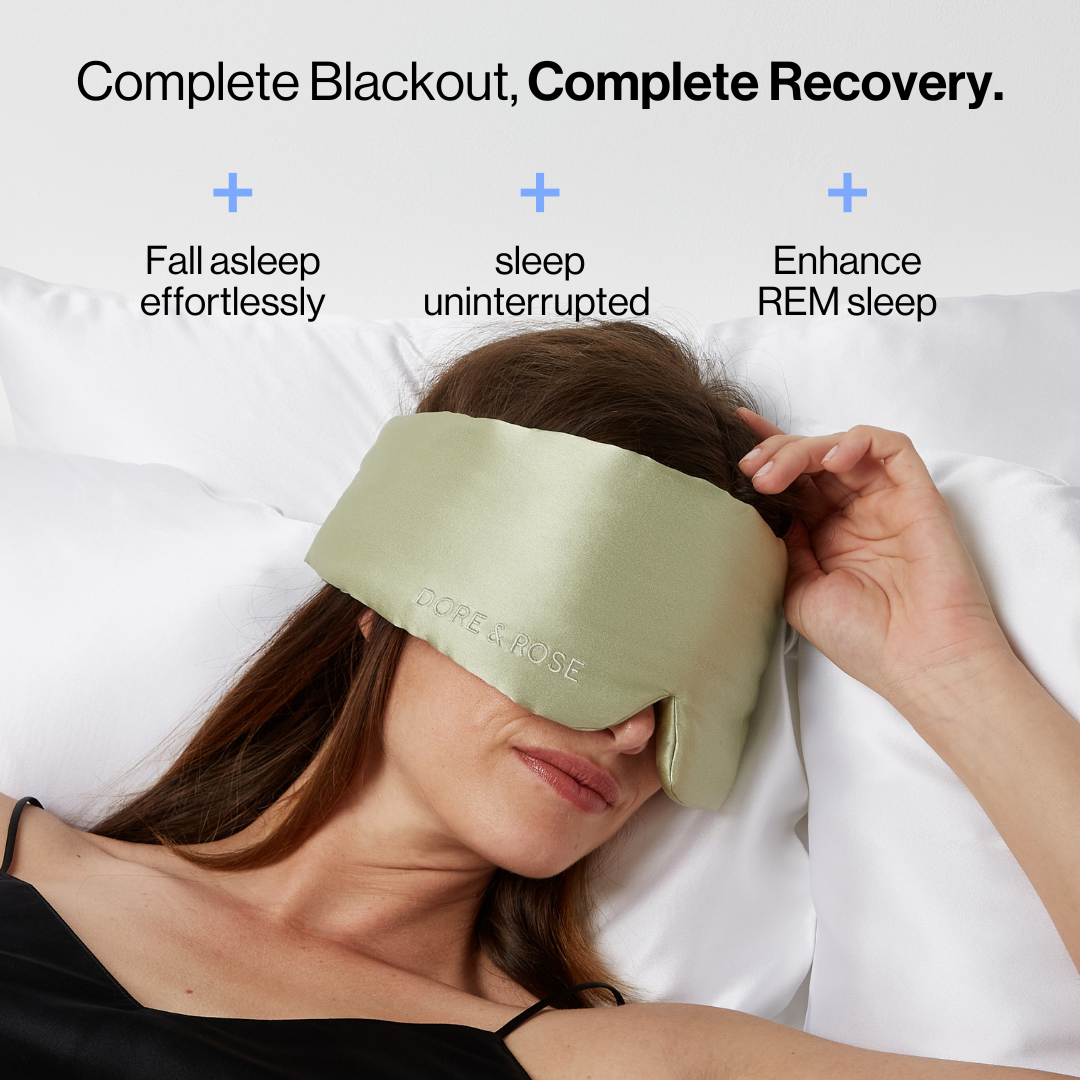 Woman sleeping wearing the Dore and Rose Luxury Soft Silk Sleeping Eye Mask in the color olive green with its benefits written on the top part