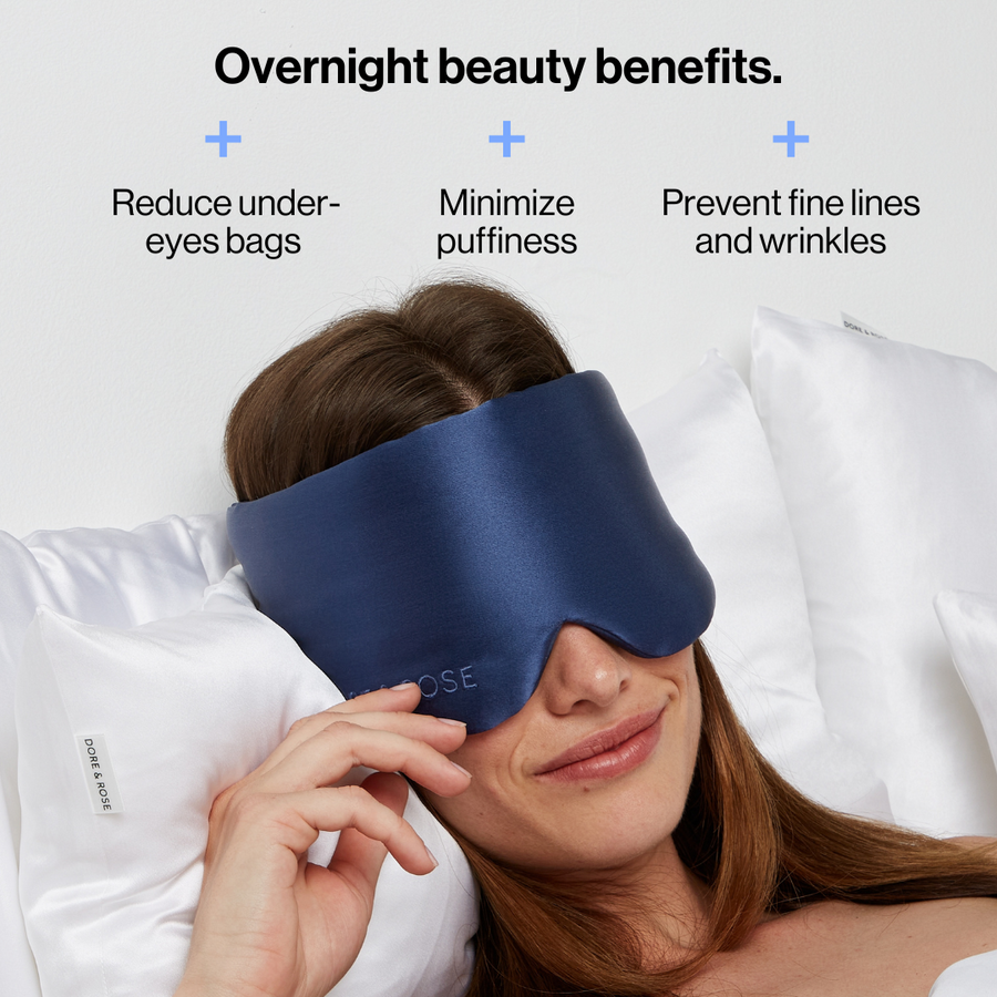 Woman wearing the Dore and Rose Luxury Soft Silk Sleeping Eye Mask in the color navy blue with its benefits written on the top part