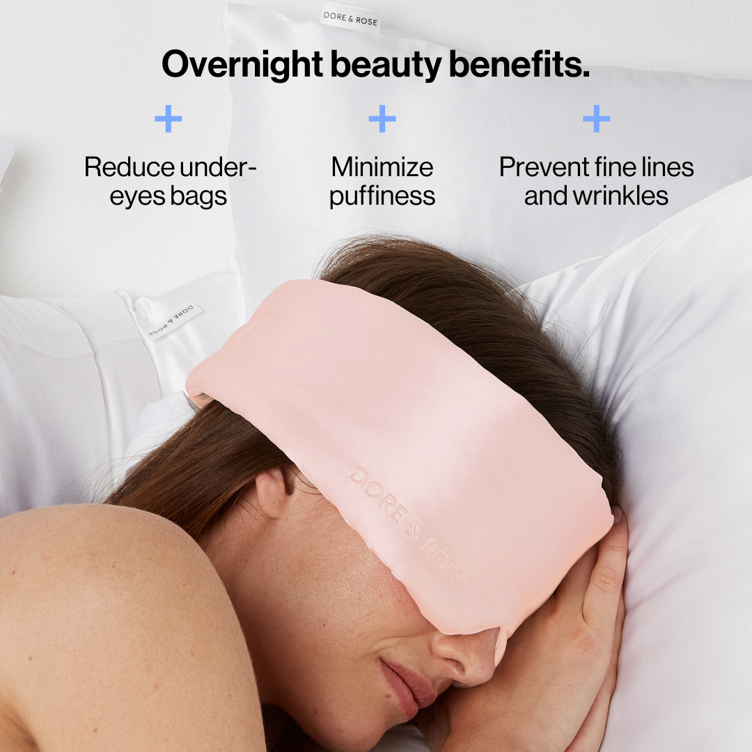 Woman sleeping wearing a Luxury Soft Silk Sleeping Eye Mask from Dore and Rose in the color light pink with its benefits written on the top part