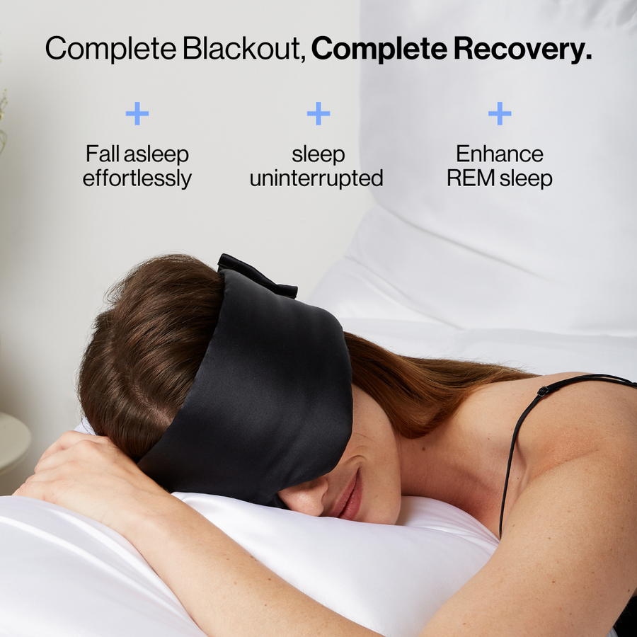 Woman sleeping wearing the Dore and Rose Luxury Soft Silk Sleeping Eye Mask in the color black with its benefits written on the top part