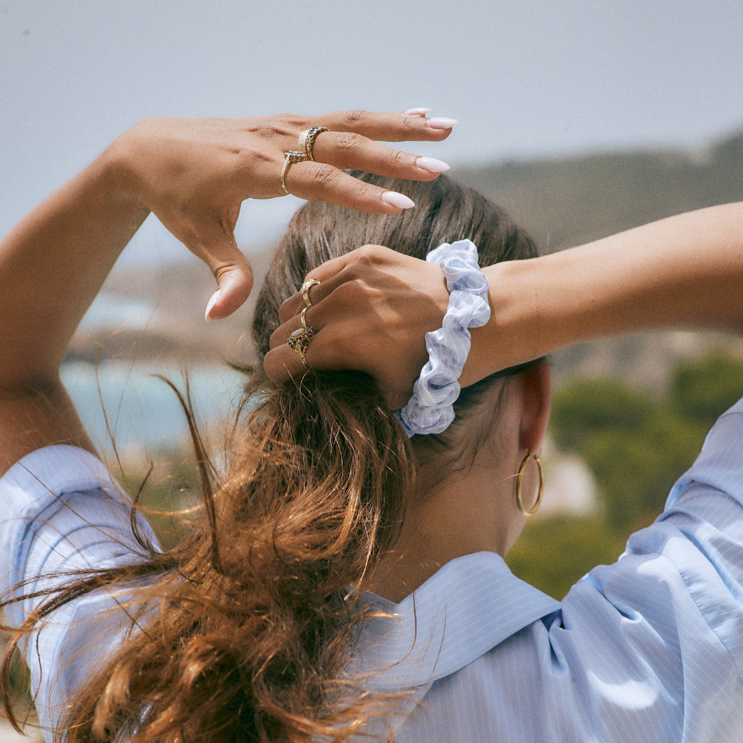 Woman about to tie her hair with a Silk Large Scrunchie in Blue and White stripes from Dore and Rose