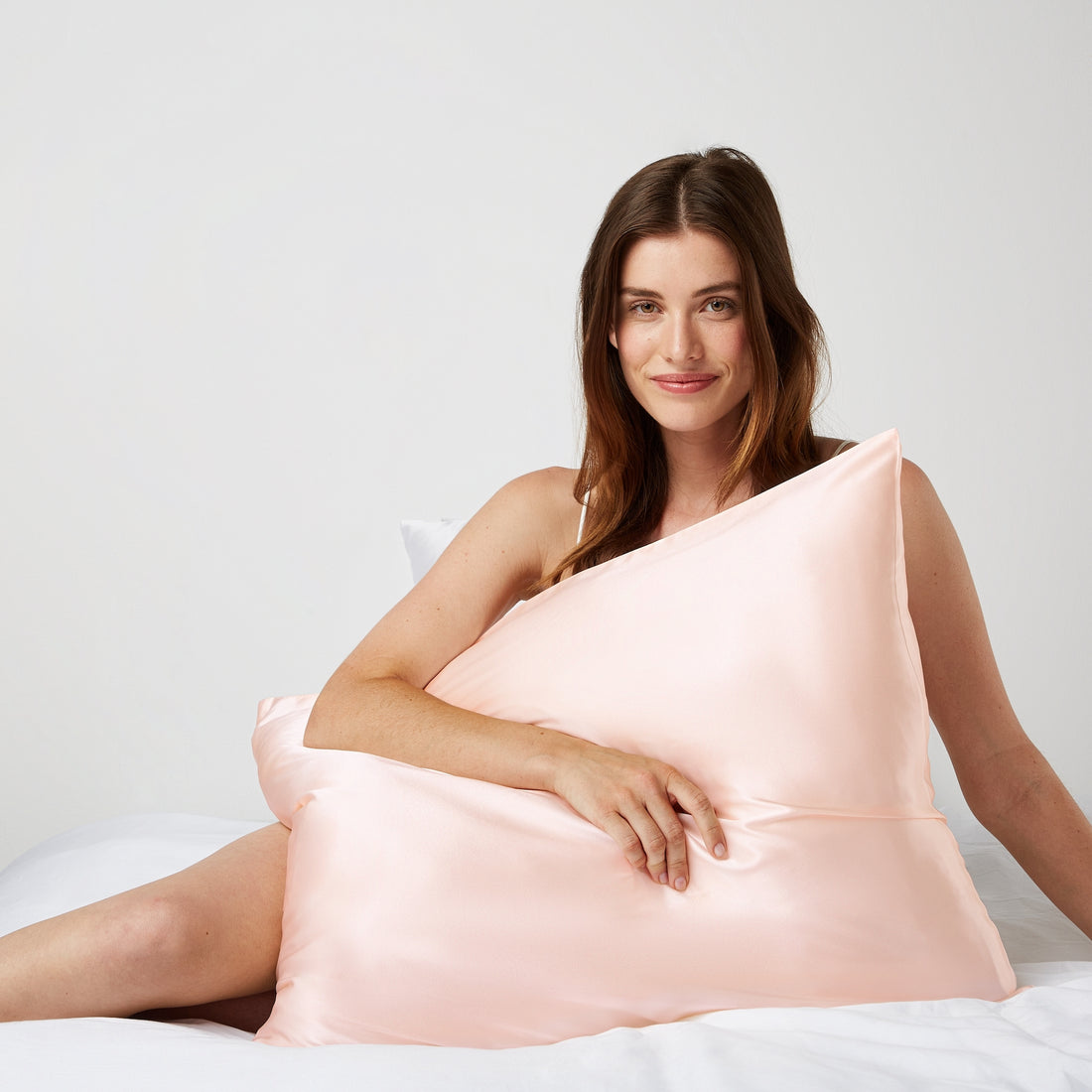 Woman hugging a pillow with a pink pillowcase