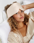 Woman lying on a bed wearing a Beige Silk Sleeping Mask