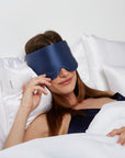 Woman lying on the bed wearing a Blue Silk Sleeping Mask